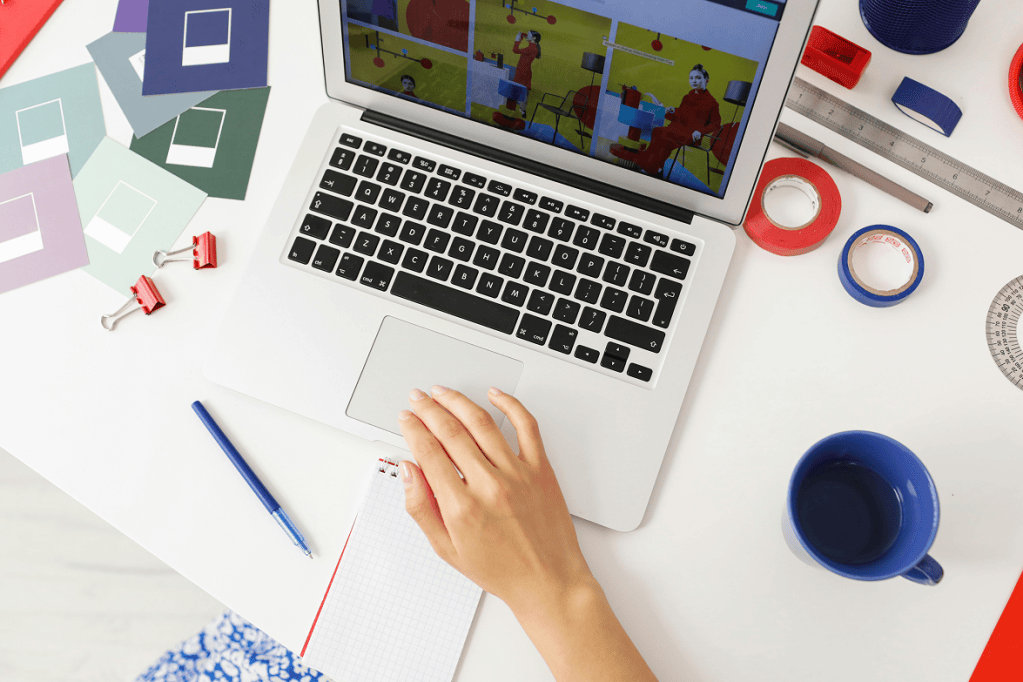 Person planning affiliate content at a desk with a laptop, colorful paper swatches, and office supplies.